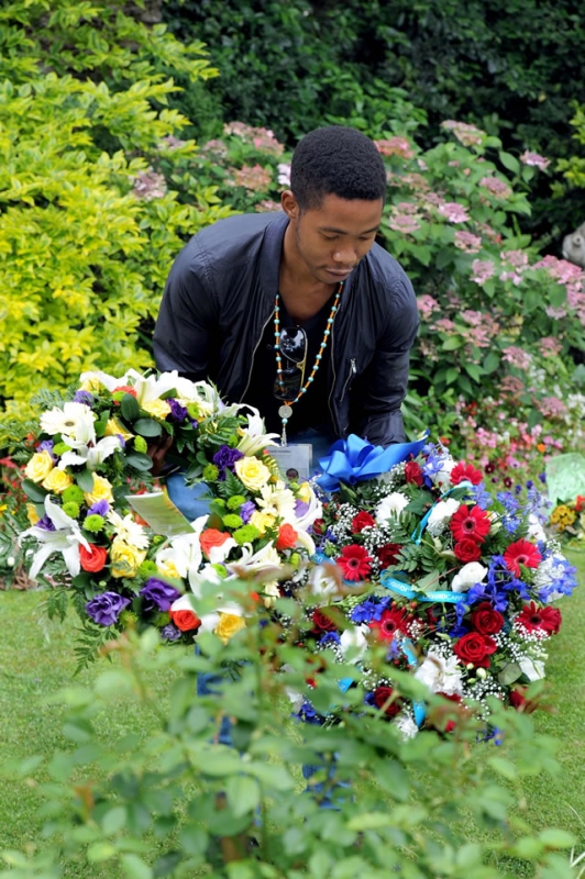 Madiba's grandson Mbuso collecting tribute flowers from the public. Source: GCIS