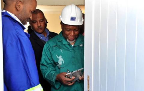 Deputy President Motlanthe helps fix the door at December Jafta's house in Zwide. Source: GCIS